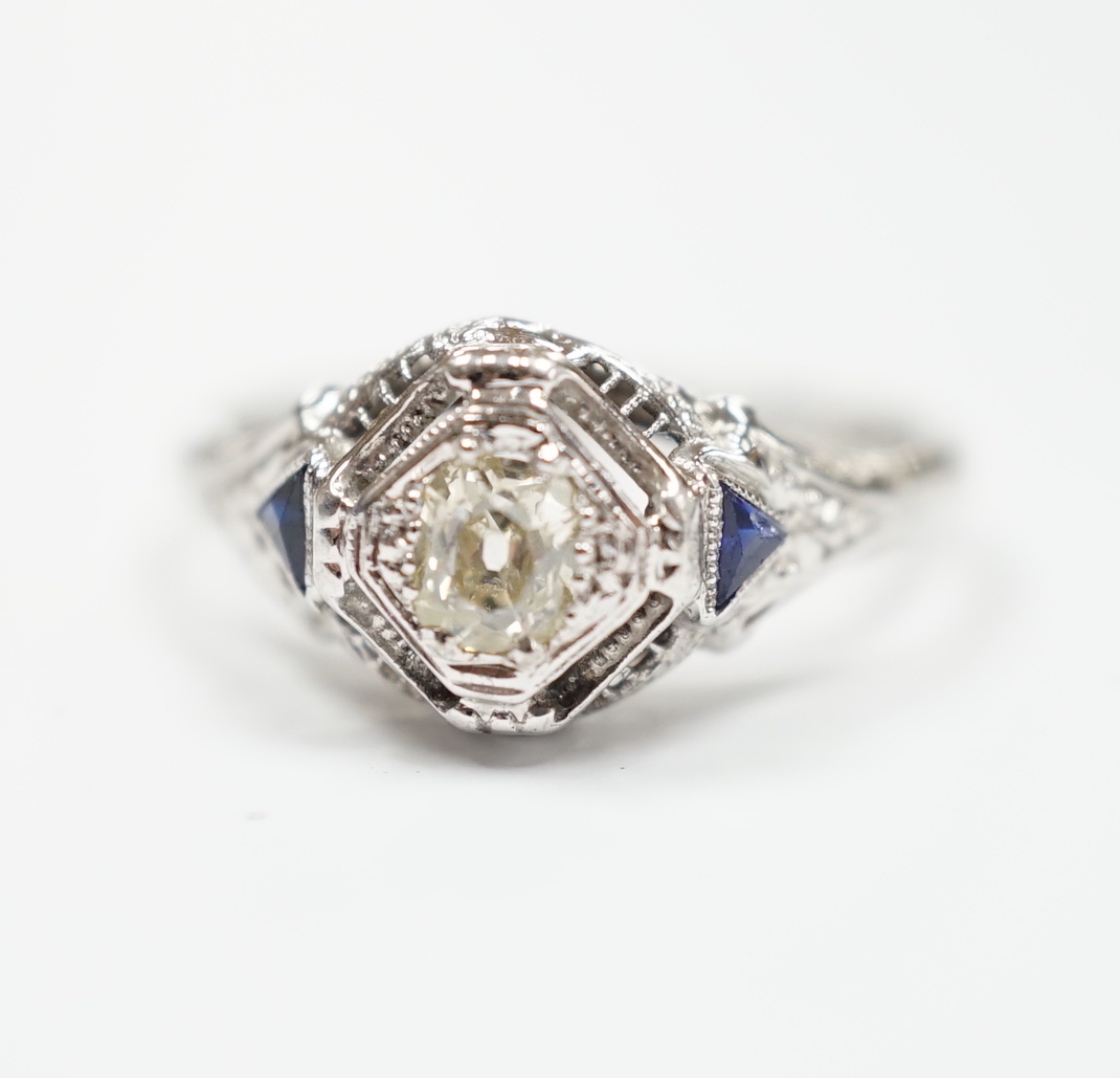 An 18ct and single stone diamond set ring, with two stone triangular sapphire set shoulders, size P, gross weight 3.1 grams.